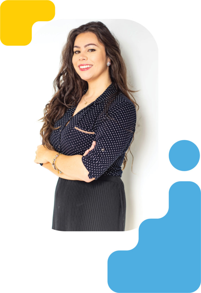 Woman wearing business casual black dress, standing with her arms crossed and smiling against an all-white background